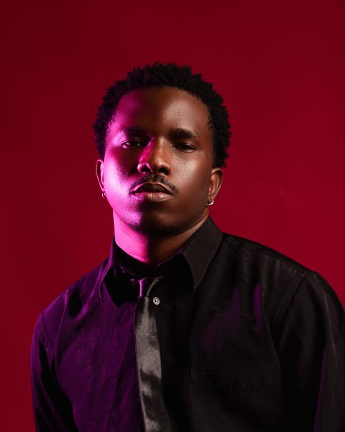 Free Moody portrait of a man against a red backdrop, wearing a black shirt. Stock Photo