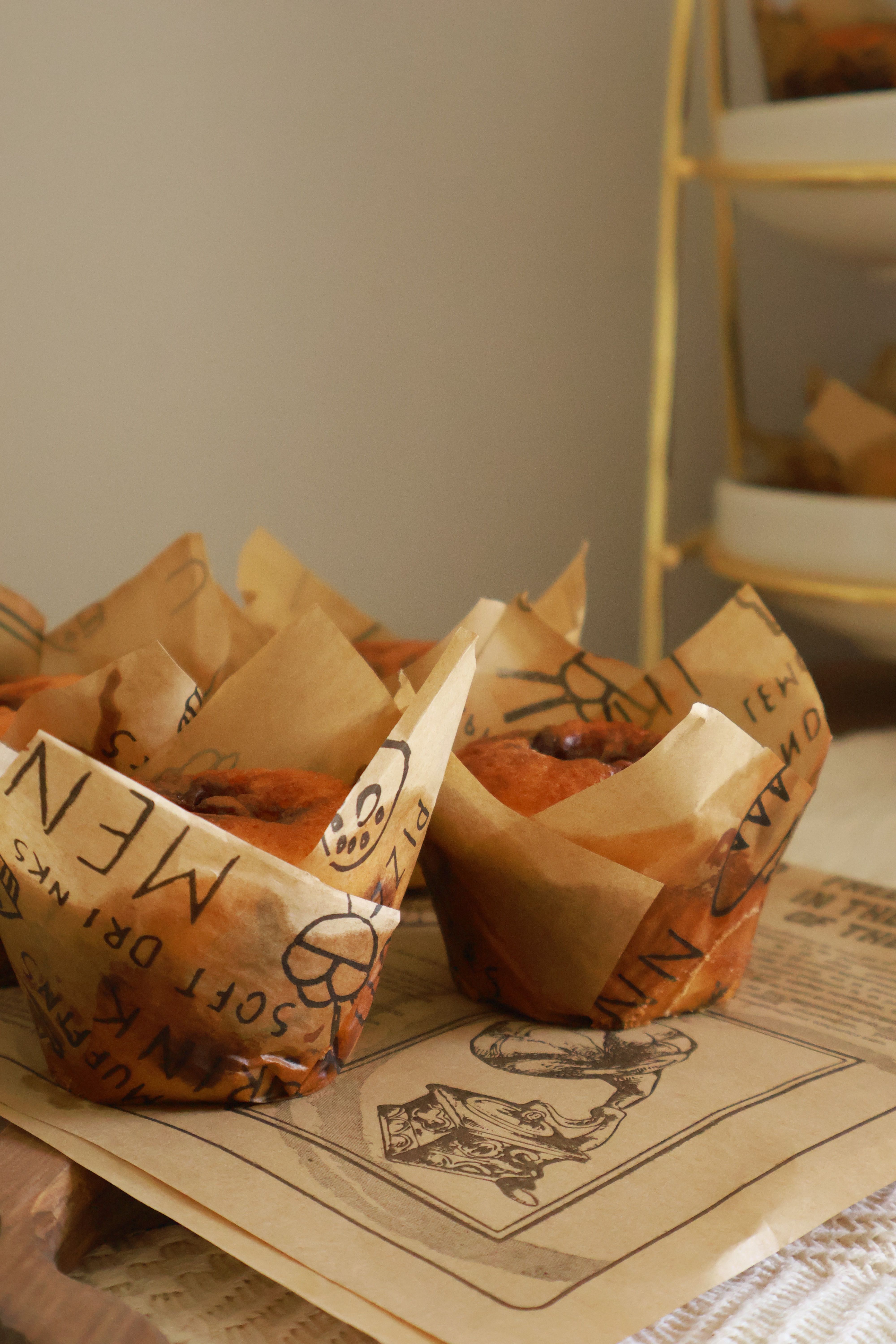 Delicious homemade muffins wrapped in unique decorative paper, perfect for a cozy breakfast.