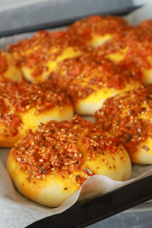 Free Freshly baked Middle Eastern mini manakish with za'atar and tomato toppings on a tray. Stock Photo