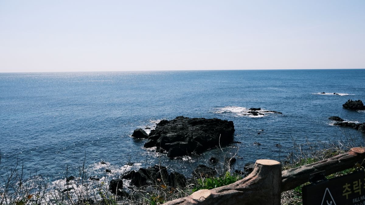 여수 1박 2일 — Experience the serene beauty of Jeju Island with this captivating view of its rugged coastline and sparkling sea.