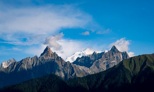 Free Breathtaking view of a majestic mountain range with snow-capped peaks under a vibrant blue sky. Stock Photo