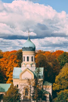 Orthodox church with a colorful dome surrounded by vivid autumn trees in Warsaw, Poland.