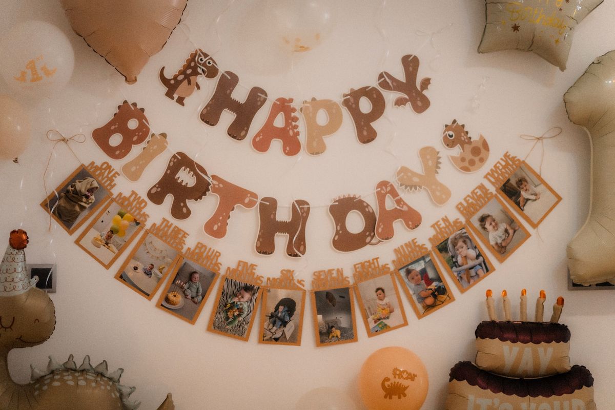 Dinosaur birthday decor with balloons and photo banner