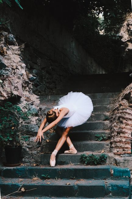 Ballerina in white tutu gracefully poses on historic Istanbul steps, creating a captivating blend of art and architecture.