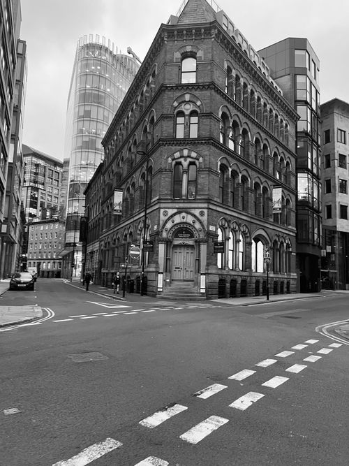 Free Black and white photo of a Victorian architectural building on an empty city street. Stock Photo