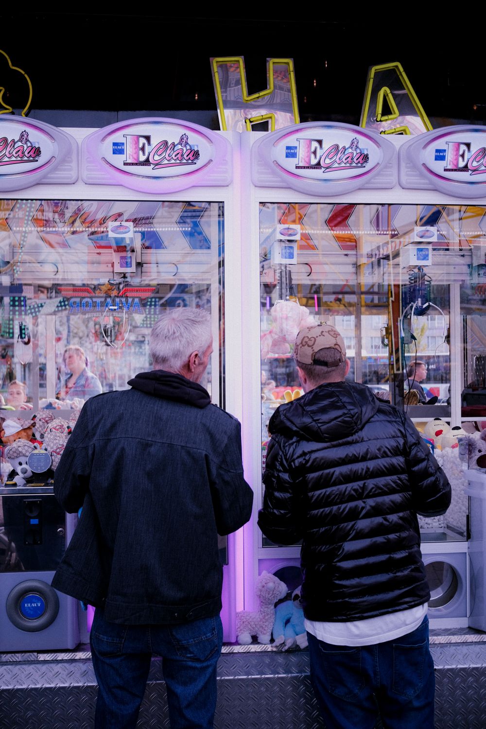 Men Enjoying Arcade Claw Machine Fun · Free Stock Photo