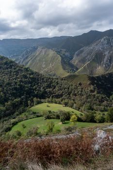 Breathtaking view of lush green valleys and rugged mountains in Asturias, Spain.