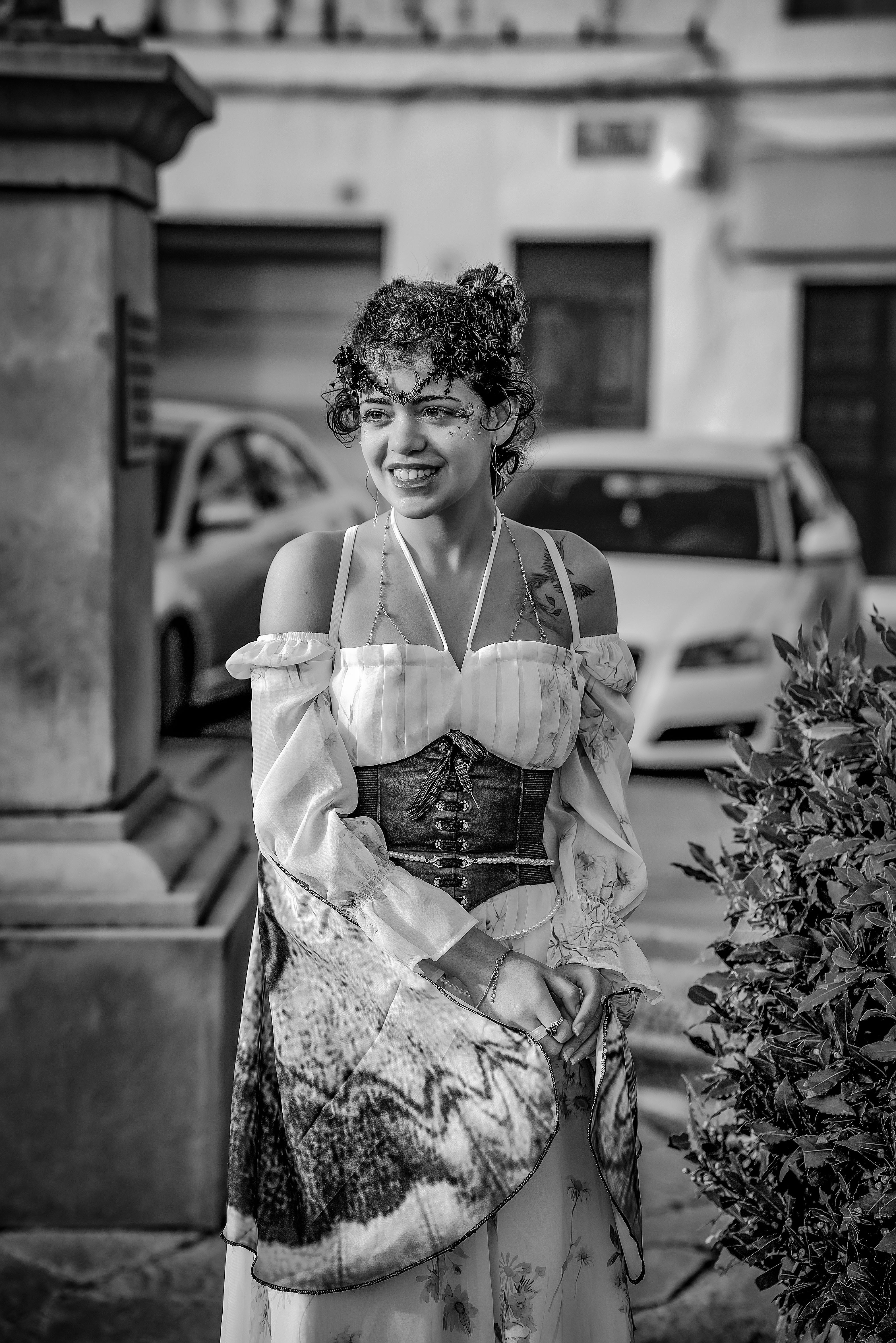 Fotomural Fotografía en blanco y negro de una mujer con atuendo vintage parada al aire libre con una expresión alegre.
