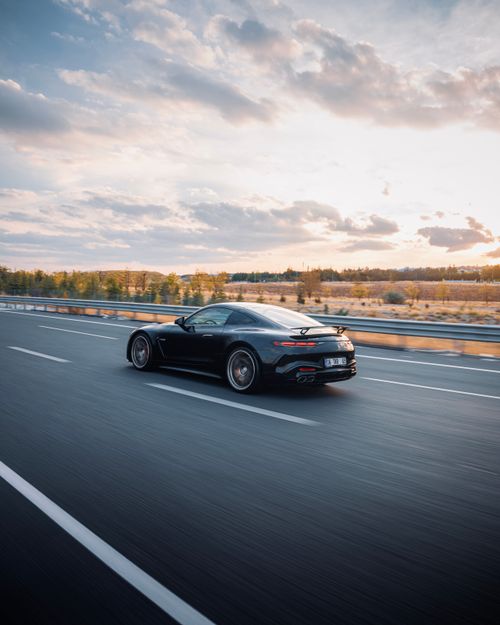 Free Elegant black car speeding on a Turkish highway during sunset, showcasing luxury and performance. Stock Photo