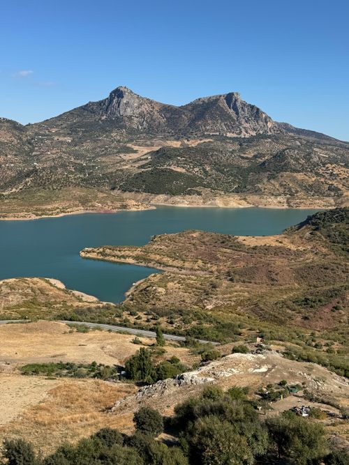 Free A breathtaking view of a serene lake surrounded by rugged mountains under a clear sky. Stock Photo