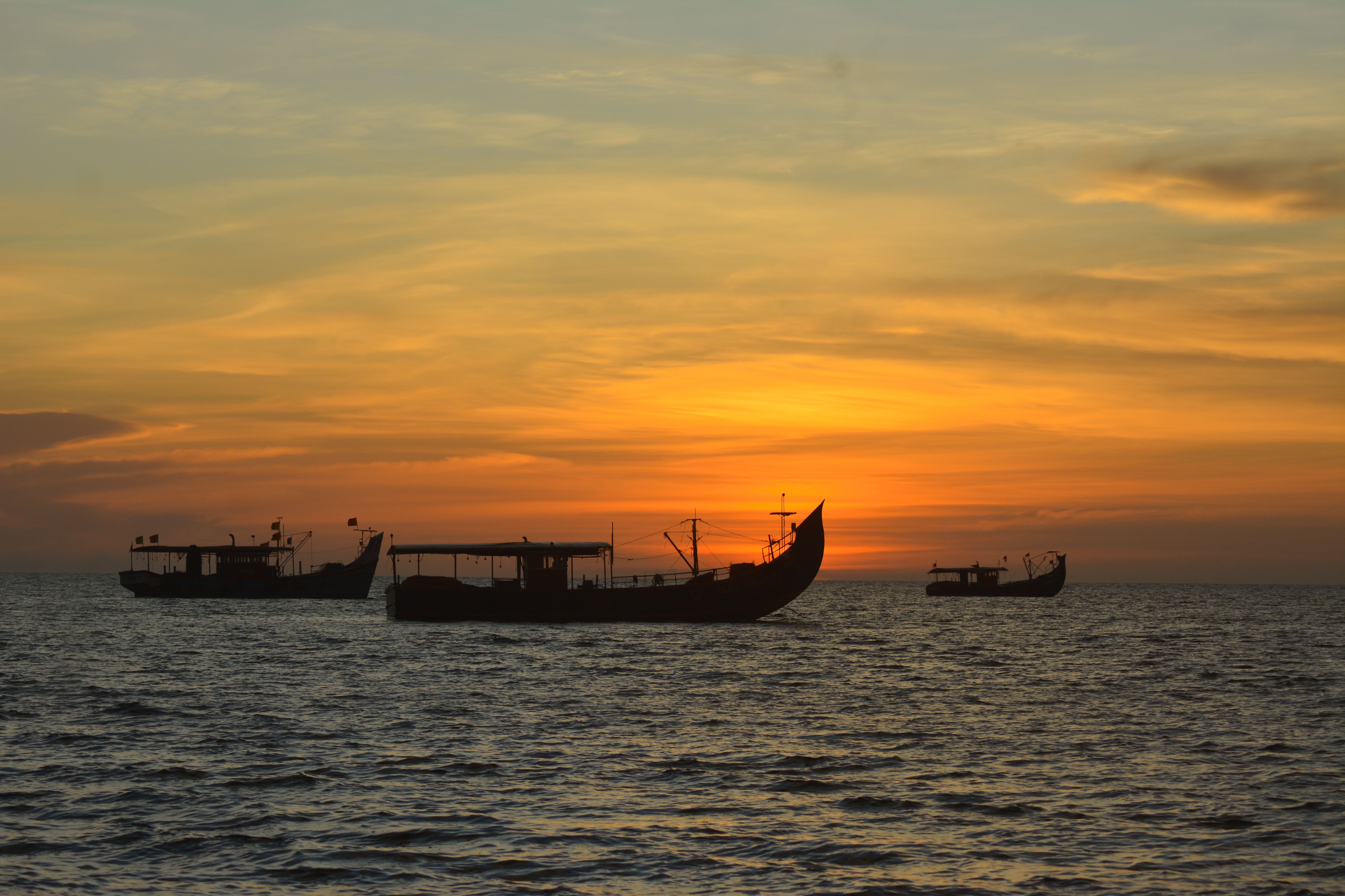 Silhouetted fishing boats against vibrant sunset, Mozambique