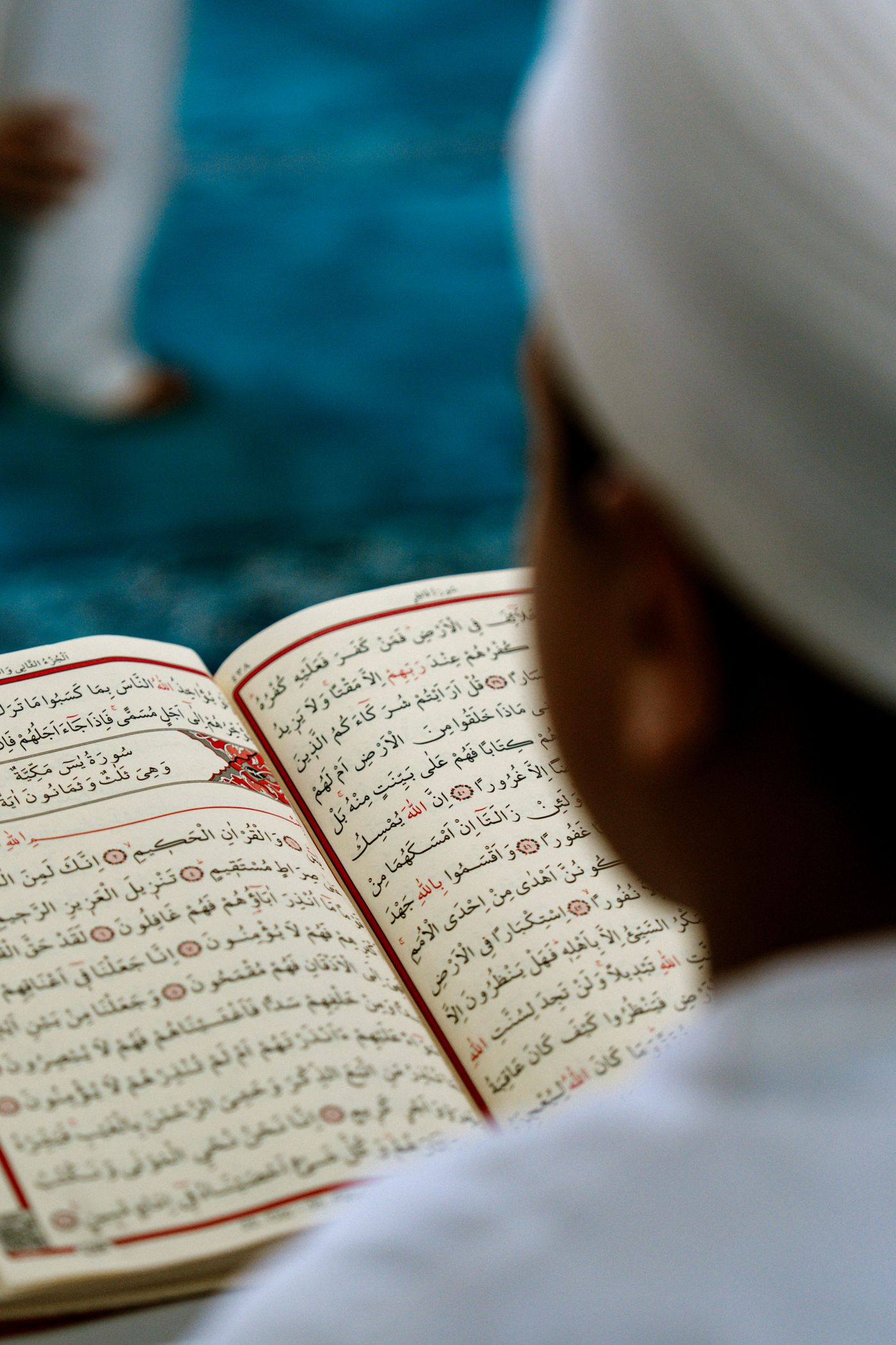 Close view of a learner reading a Quran page