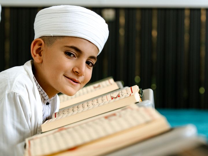 Smiling boy reading the Holy Quran