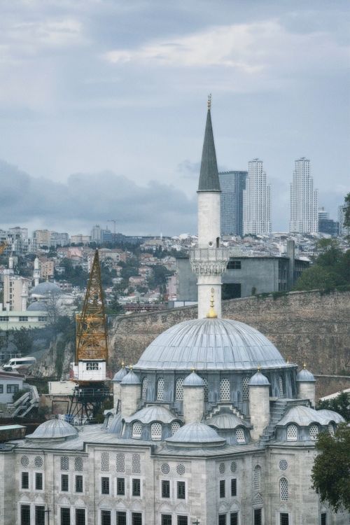 Free A mosque surrounded by urban development with a distant modern skyline. Stock Photo