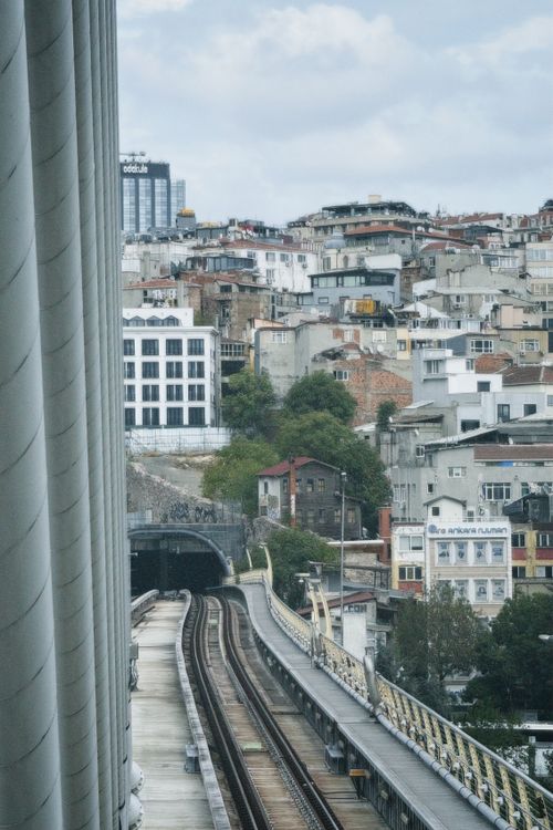 Free A modern urban cityscape featuring train tracks leading into a city full of diverse architecture. Stock Photo