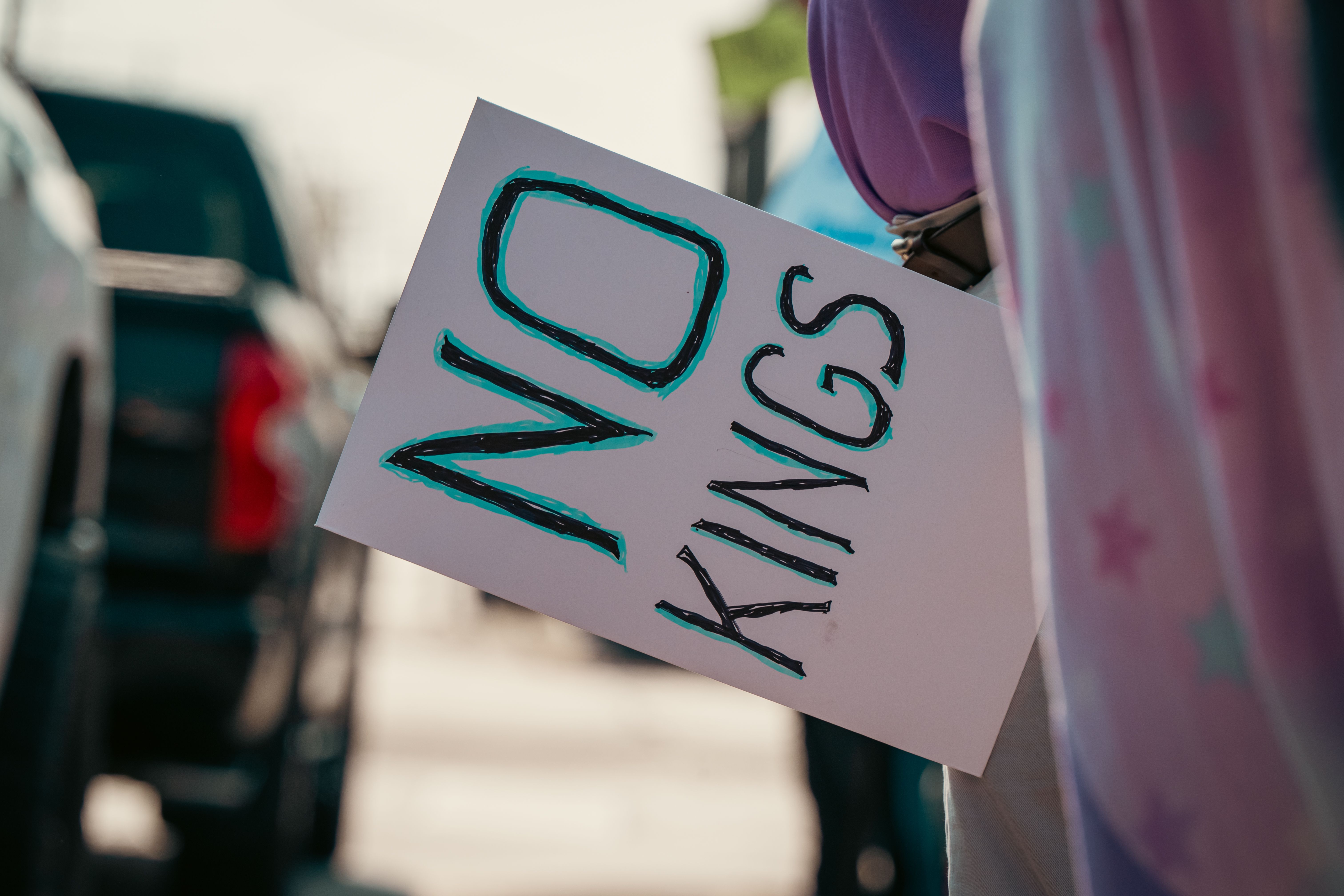 Protest Sign Reading 'No Kings' Held on Street · Free Stock Photo