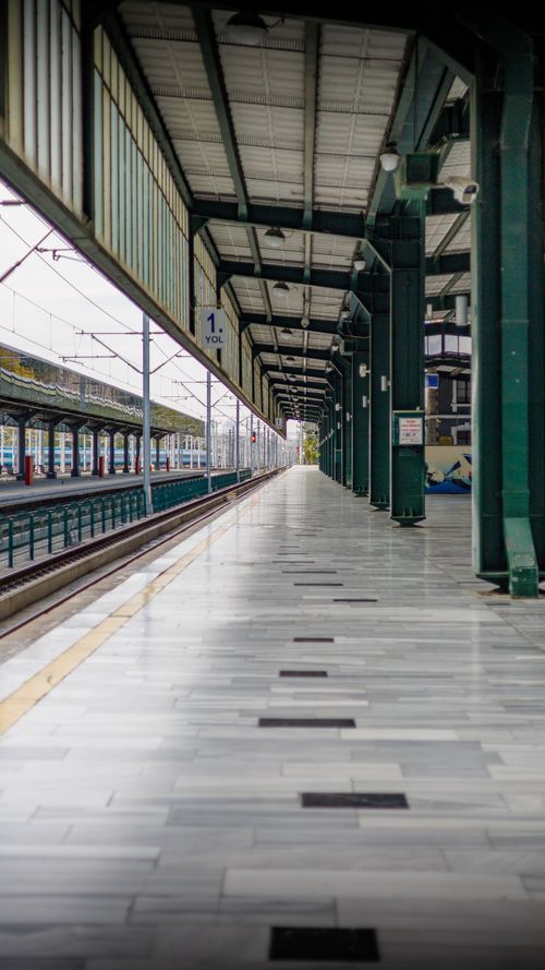 Free A modern and empty train station platform with symmetrical pillars and tracks, showing perspective. Stock Photo