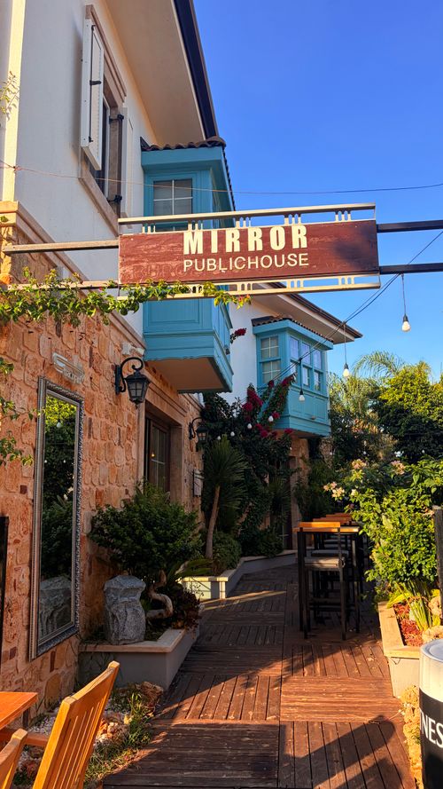 Free Outdoor seating area of Mirror Public House with rustic charm, vibrant plants. Stock Photo