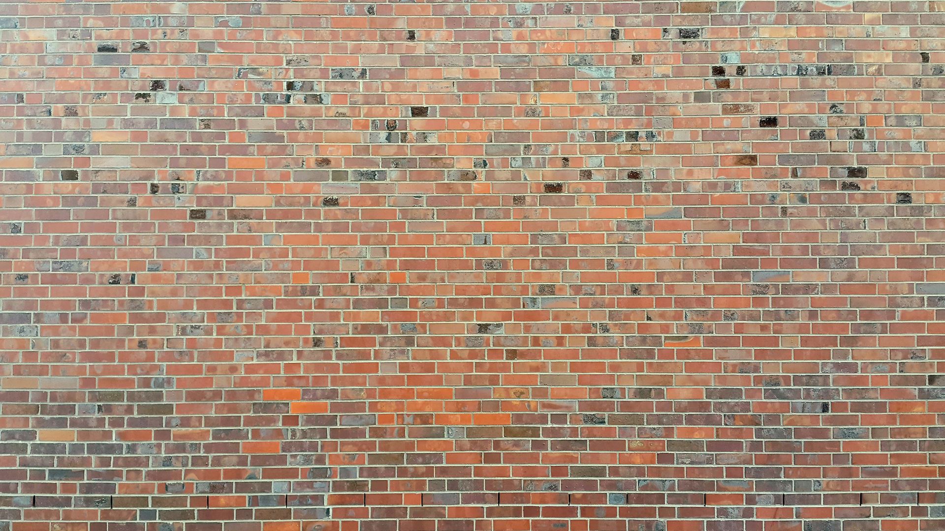 Detailed view of a red brick wall showing texture and pattern for backgrounds or design.