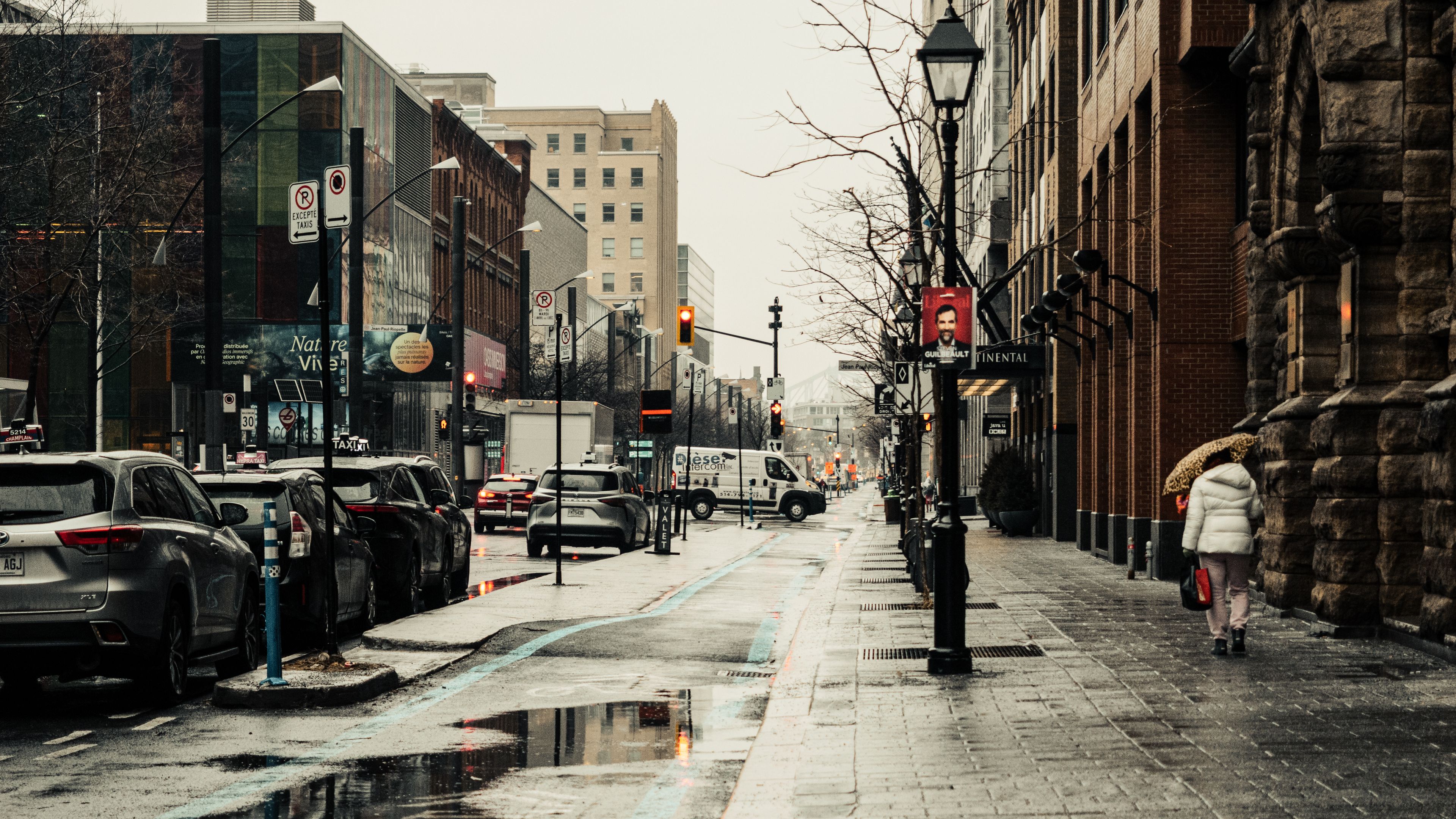 A rainy day scene on Sainte-Catherine Street in Montreal capturing urban life and architecture.