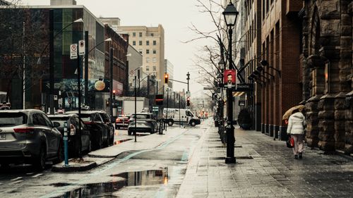 Free A rainy day scene on Sainte-Catherine Street in Montreal capturing urban life and architecture. Stock Photo