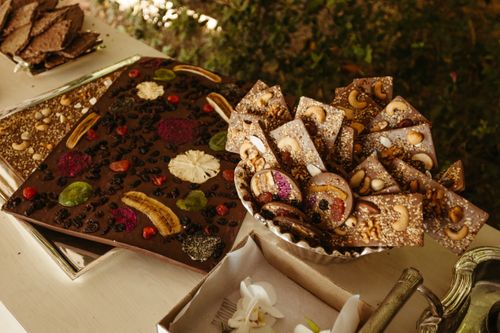 Free Artisan chocolate bars garnished with cashews, almonds, and dried fruits elegantly displayed. Stock Photo