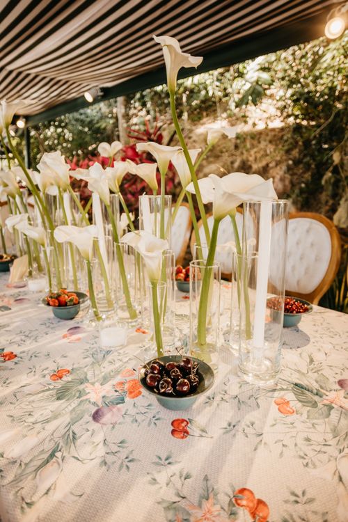 Free Beautiful table setting with calla lilies and fresh cherries, ideal for elegant events. Stock Photo