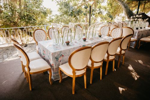 Free Beautifully arranged outdoor dining table with elegant chairs and floral decor perfect for events. Stock Photo