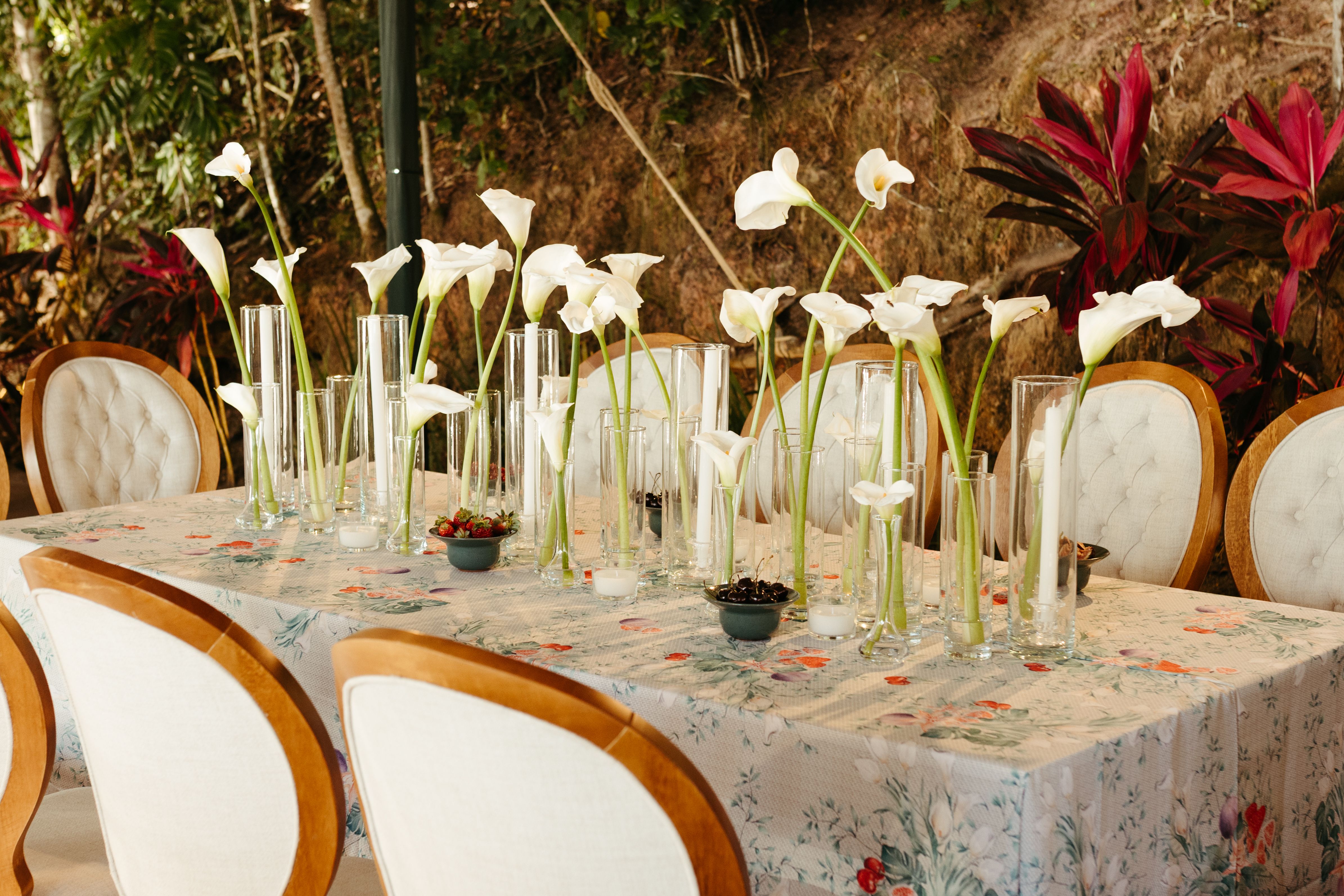 Beautiful outdoor dining table adorned with white Calla Lilies and elegant chairs, perfect for special occasions.
