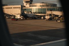 Airport terminal captured from airplane window during day. Suitable for travel and aviation themes.