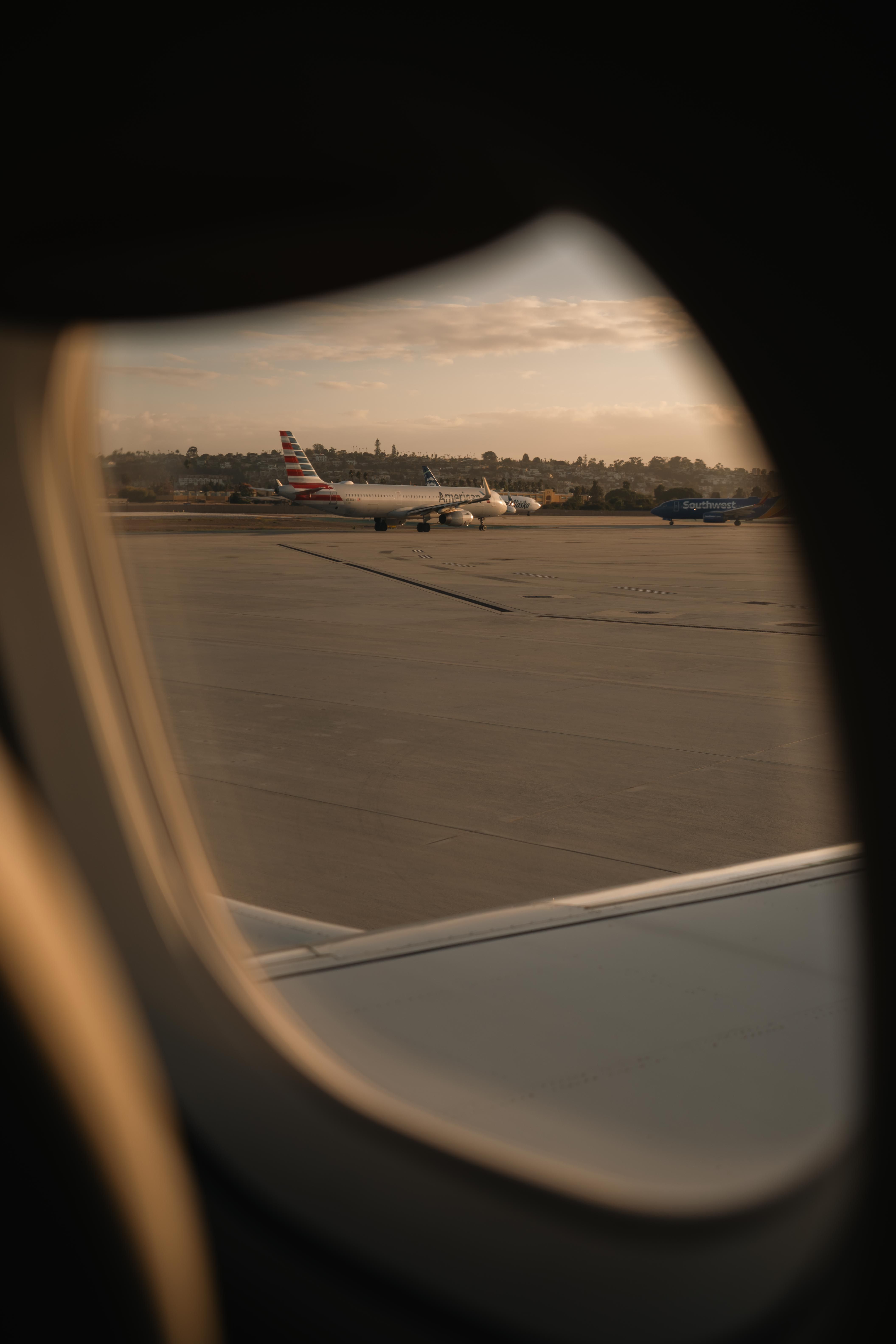 Airplane view from window at sunset on airport runway · Free Stock Photo