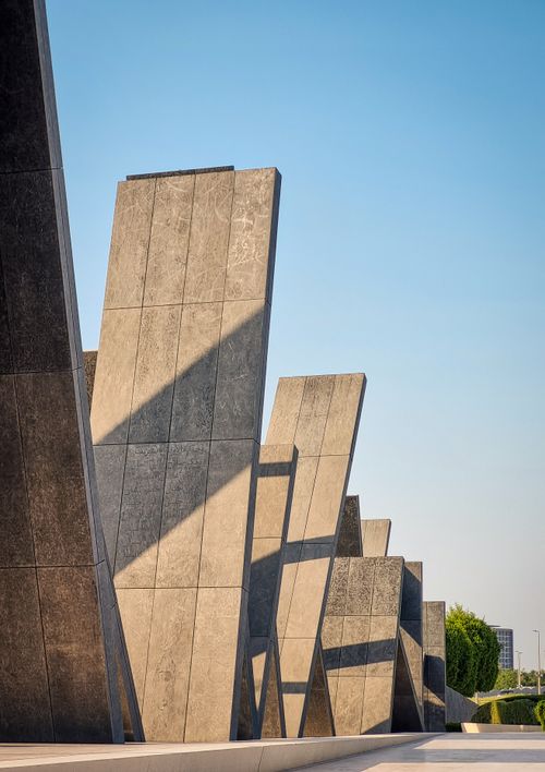 Free Abstract pillars casting shadows at an architectural site in Abu Dhabi, UAE. Stock Photo