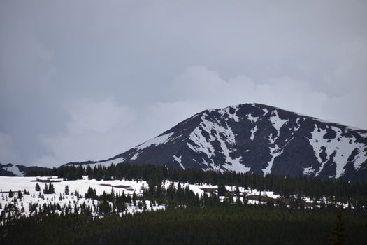 Breathtaking view of snow-covered peaks and dramatic skies in the Colorado Rockies.