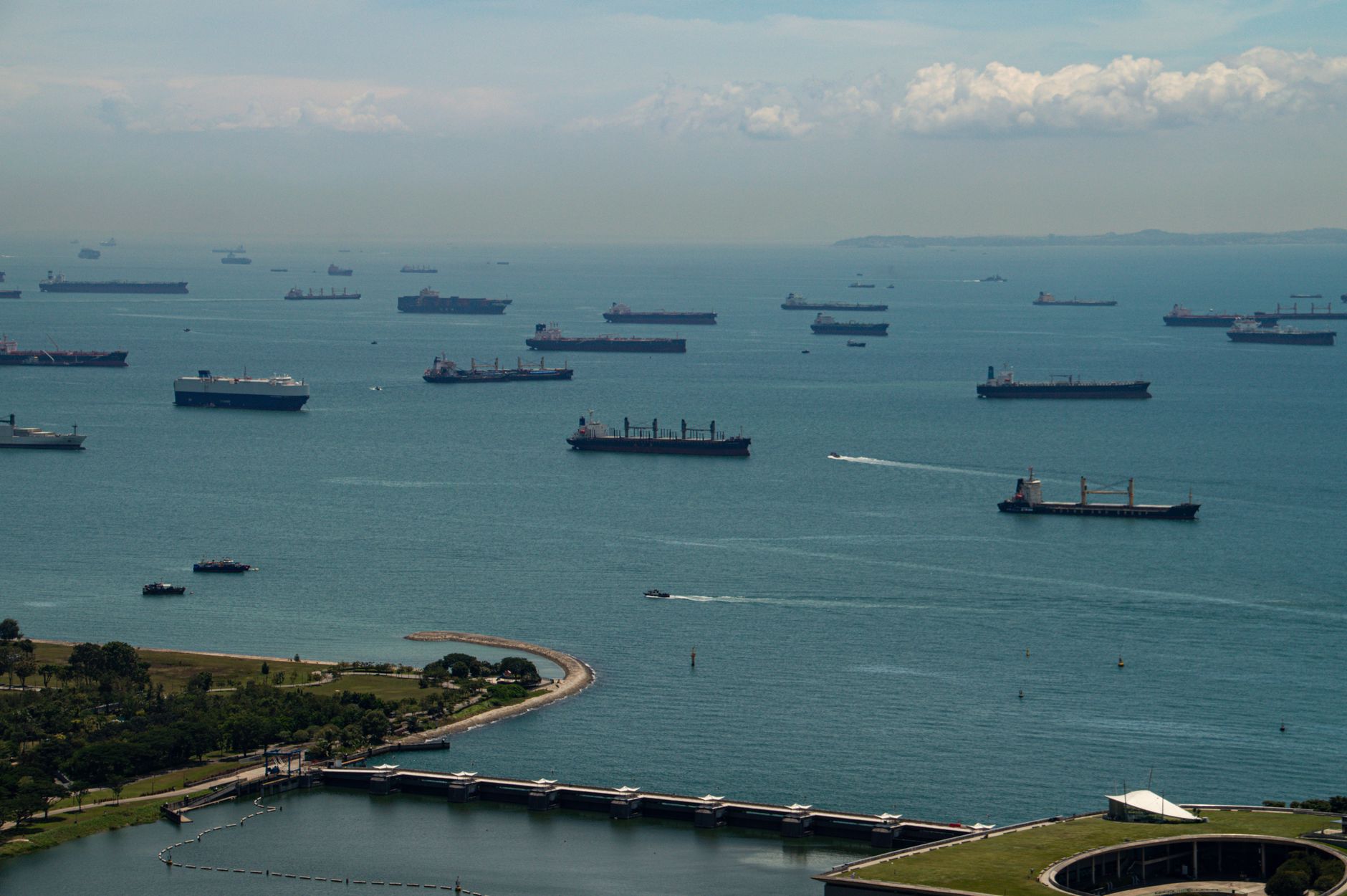 Aerial view of ships anchored in the Singapore Strait under a clear sky, showcasing maritime activity.