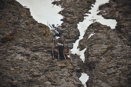 Free Explore an abandoned mine set against rocky cliffs and snow patches in the Colorado Rockies. Stock Photo