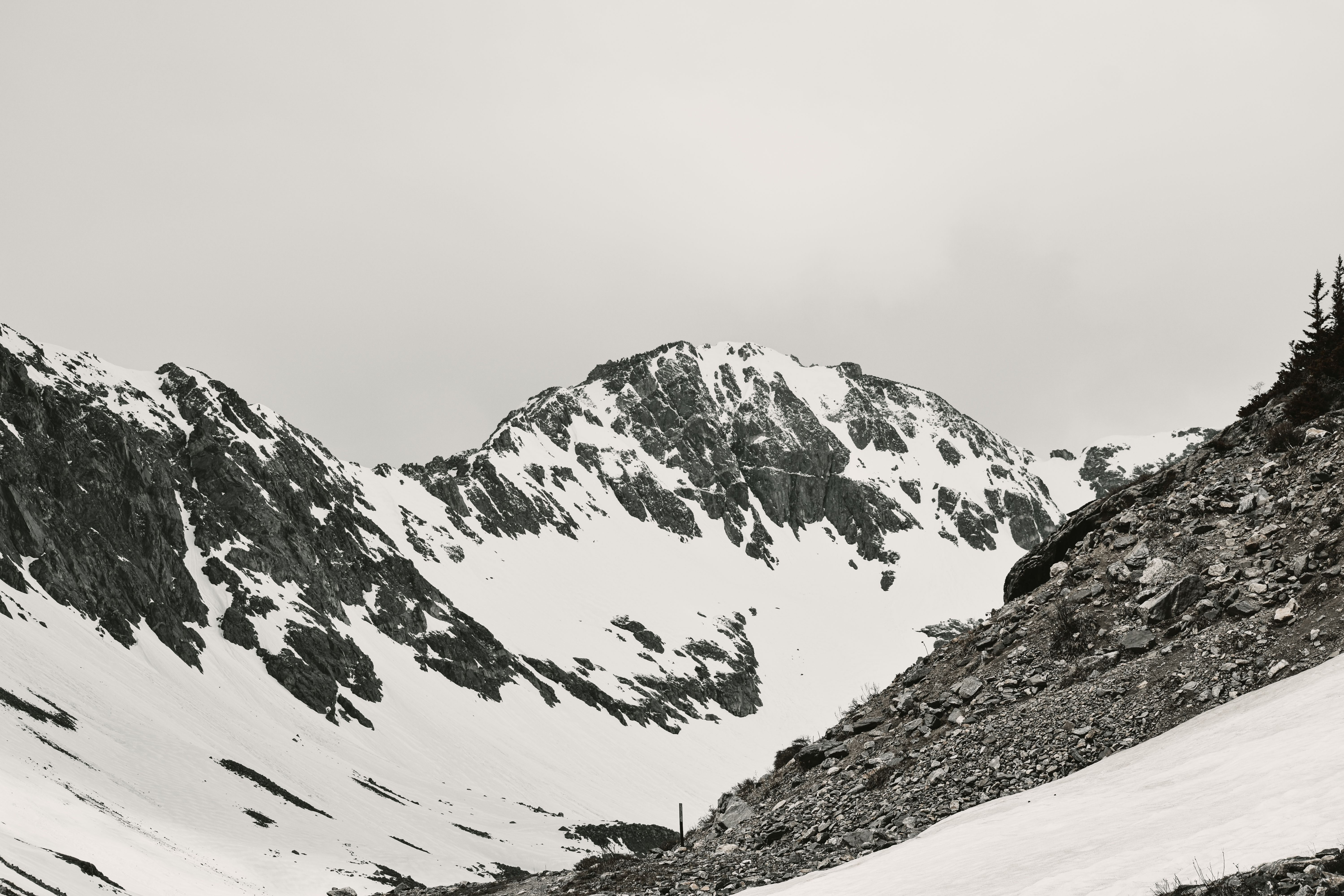 A serene black and white panorama of snow-covered rocky mountain slopes in Colorado.
