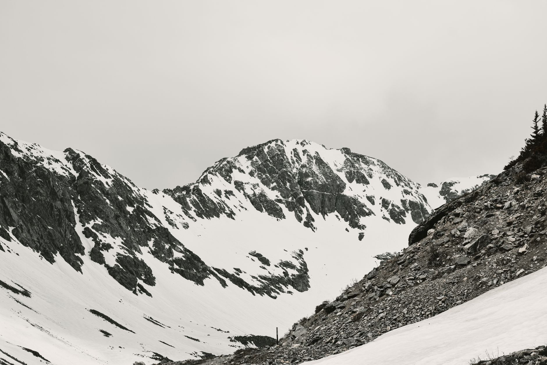 A serene black and white panorama of snow-covered rocky mountain slopes in Colorado.