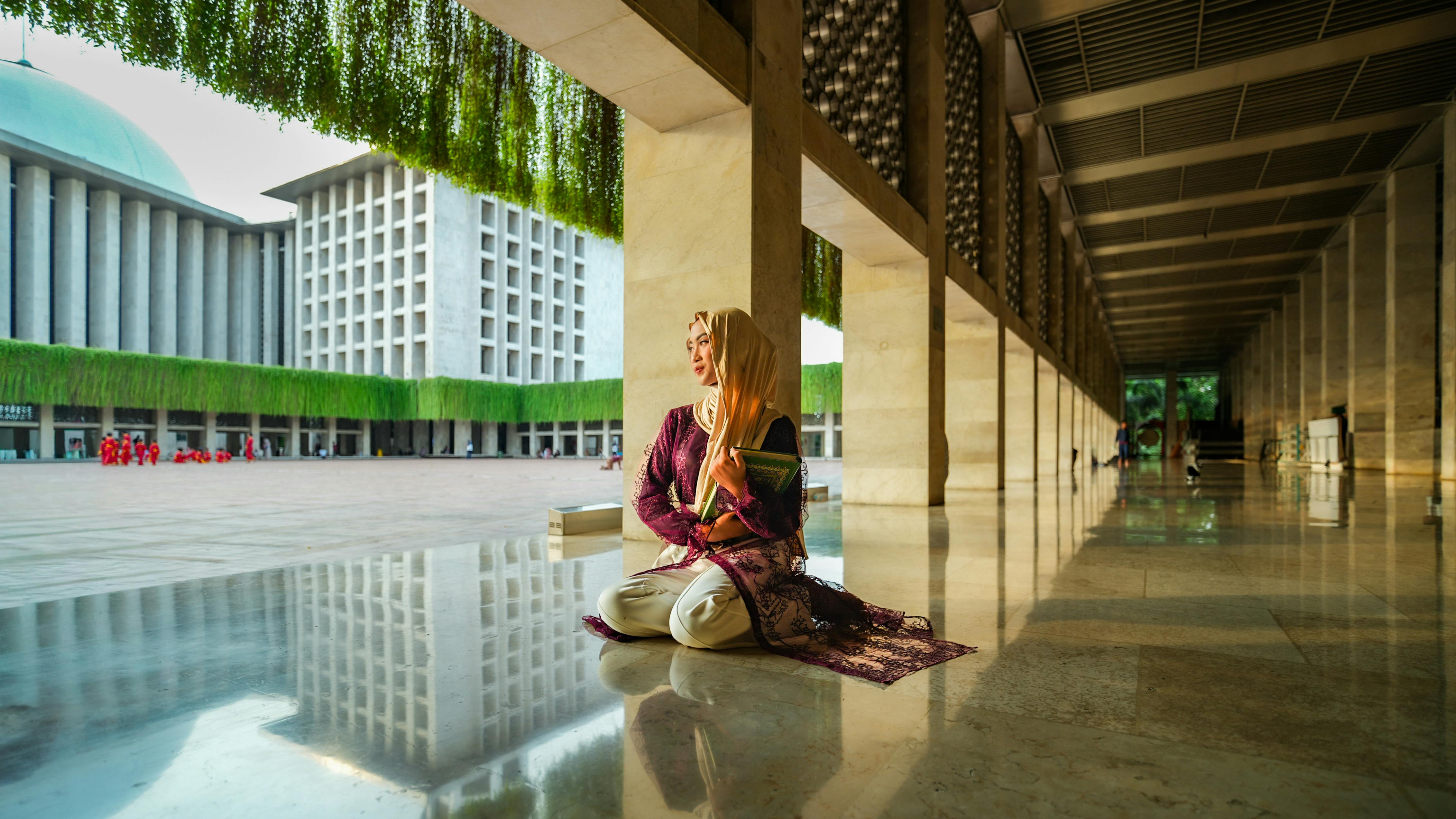 The reflection on the marble floor adds to the peaceful impression of the portrait of a woman inside the mosque.