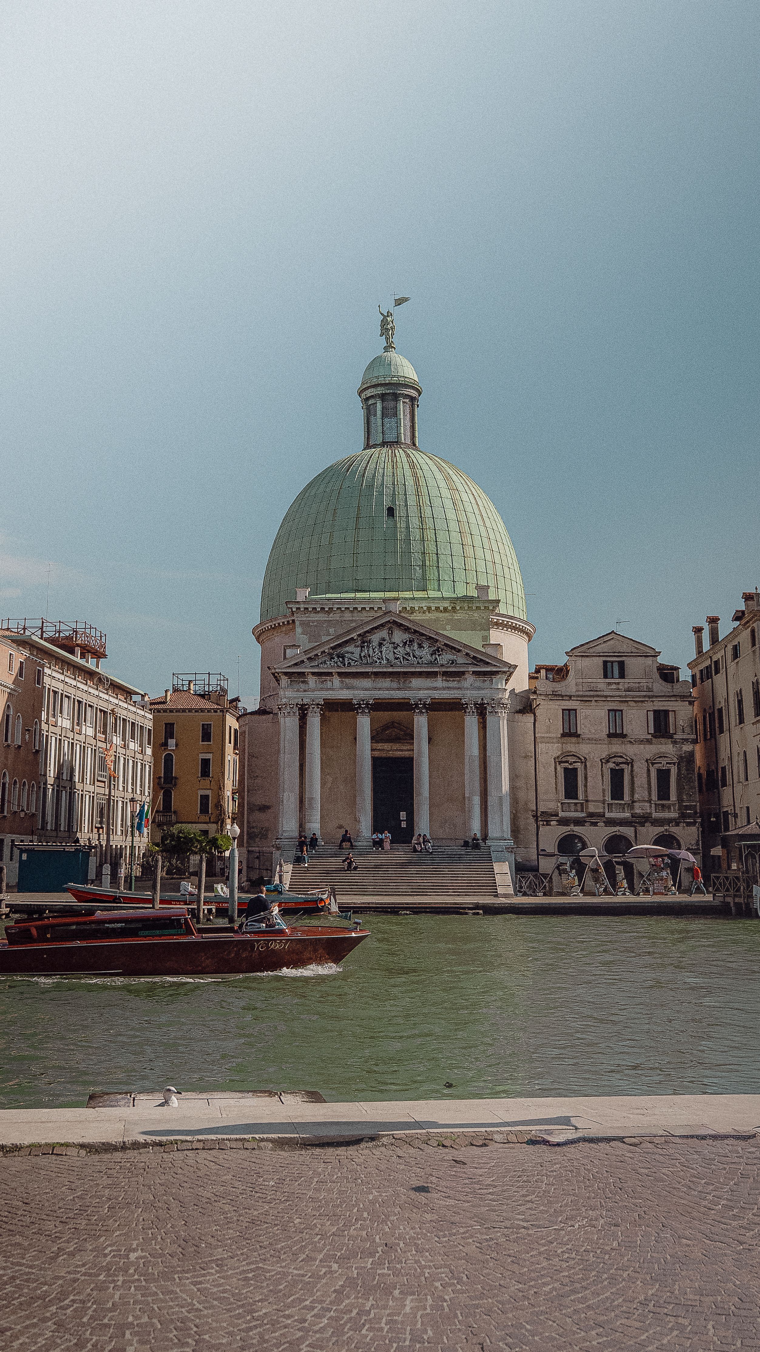 The majestic San Simeon Piccolo church by Venice's Grand Canal under a clear sky.