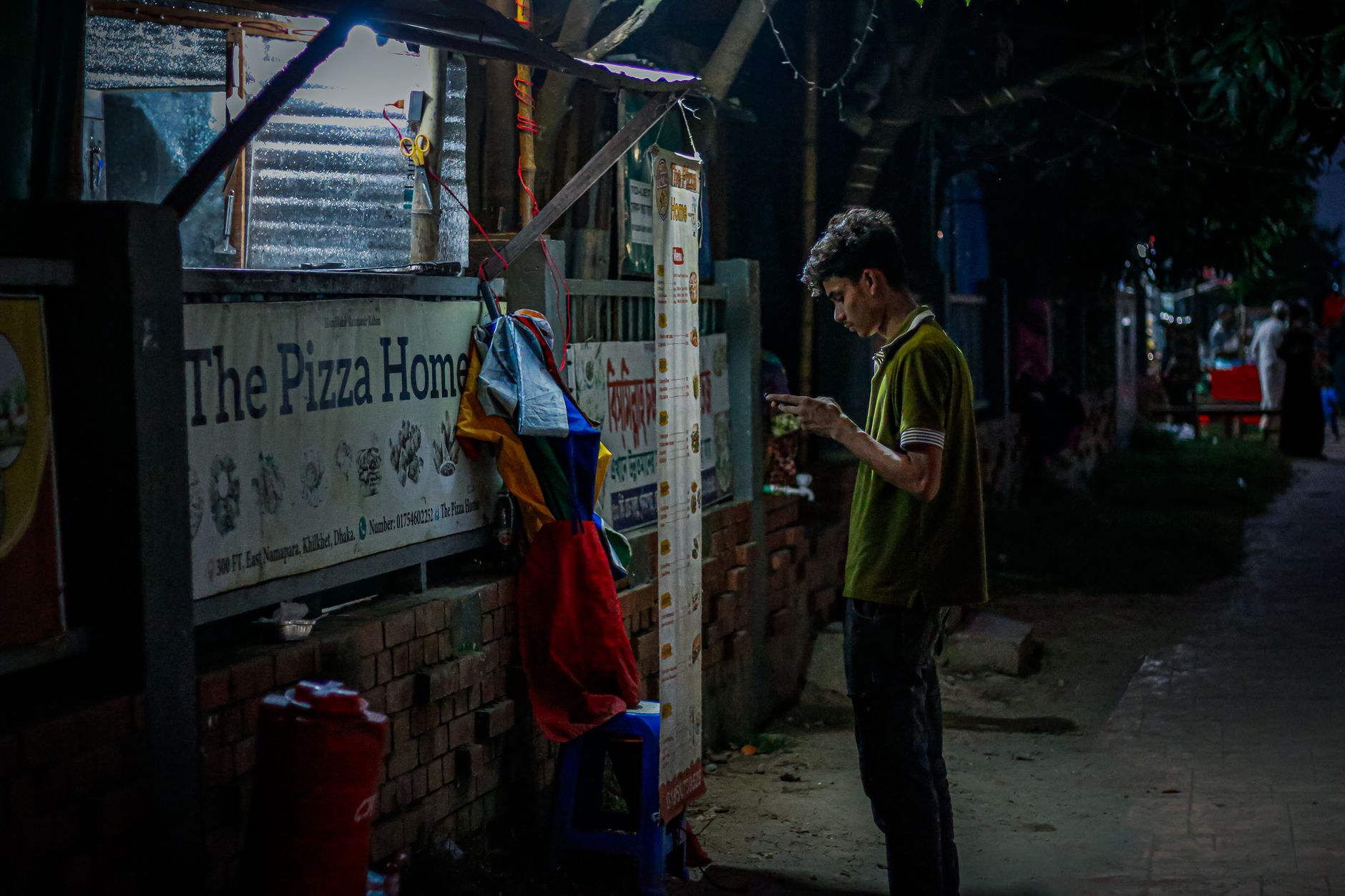 তরুণ খেলোয়াড় রাতে স্মার্টফোনে Teen Patti Master লাইভ টেবিল দেখছেন, পাশে নোটবুকে বাজেট লেখা