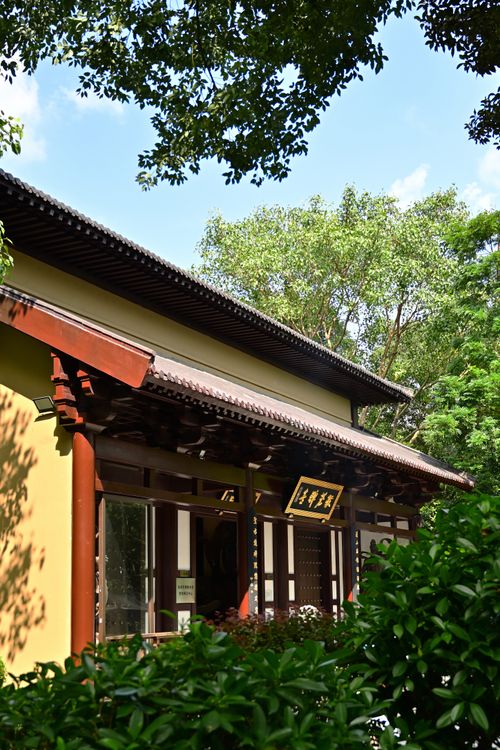 Free A traditional Asian building surrounded by greenery under a clear blue sky. Stock Photo