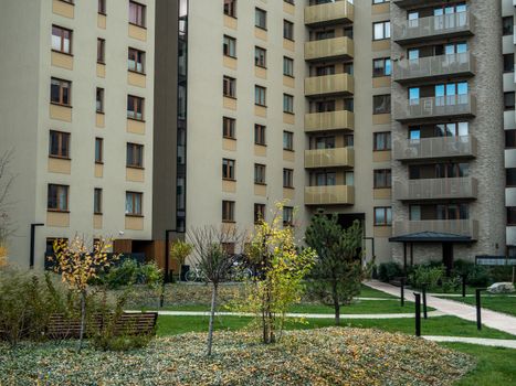 Contemporary high-rise apartment buildings with lush greenery and pathways in the courtyard.