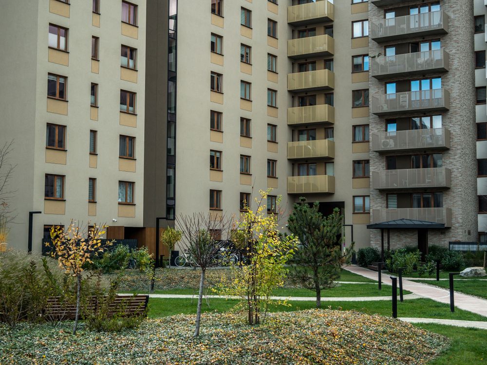 Patio comunitario con césped y caminos entre edificios de viviendas