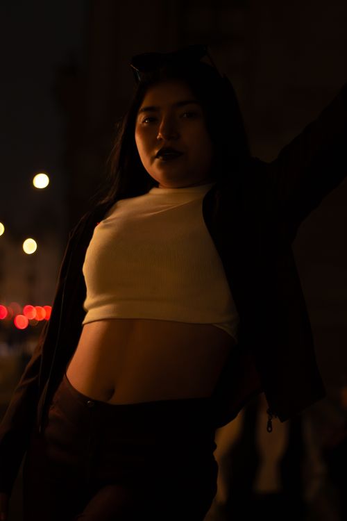 Free Stylish night portrait of a fashionable woman in Lima with a dramatic flair and bokeh background. Stock Photo