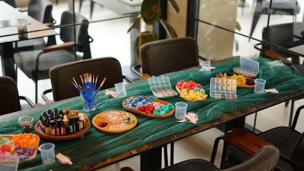 A well-organized craft table displaying vibrant art supplies like beads and brushes, perfect for creative projects.