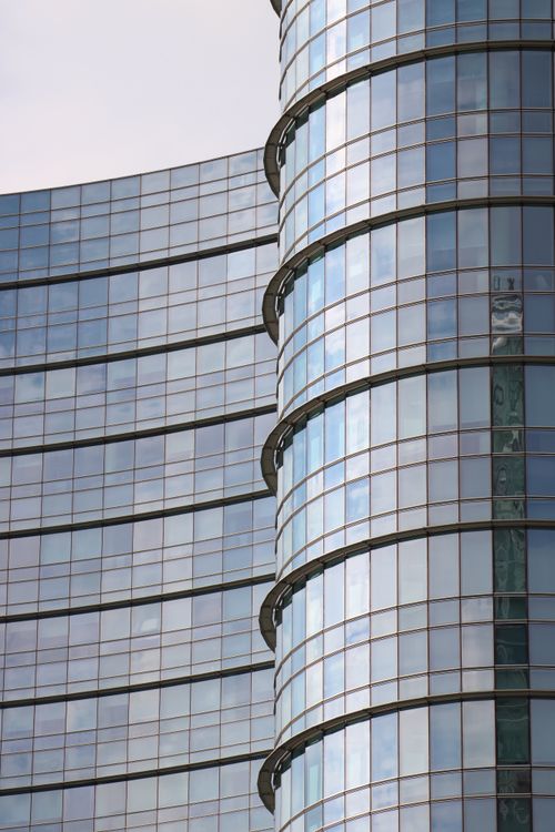 Free Close-up of a modern glass skyscraper in Milan, Italy, with reflective surfaces. Stock Photo
