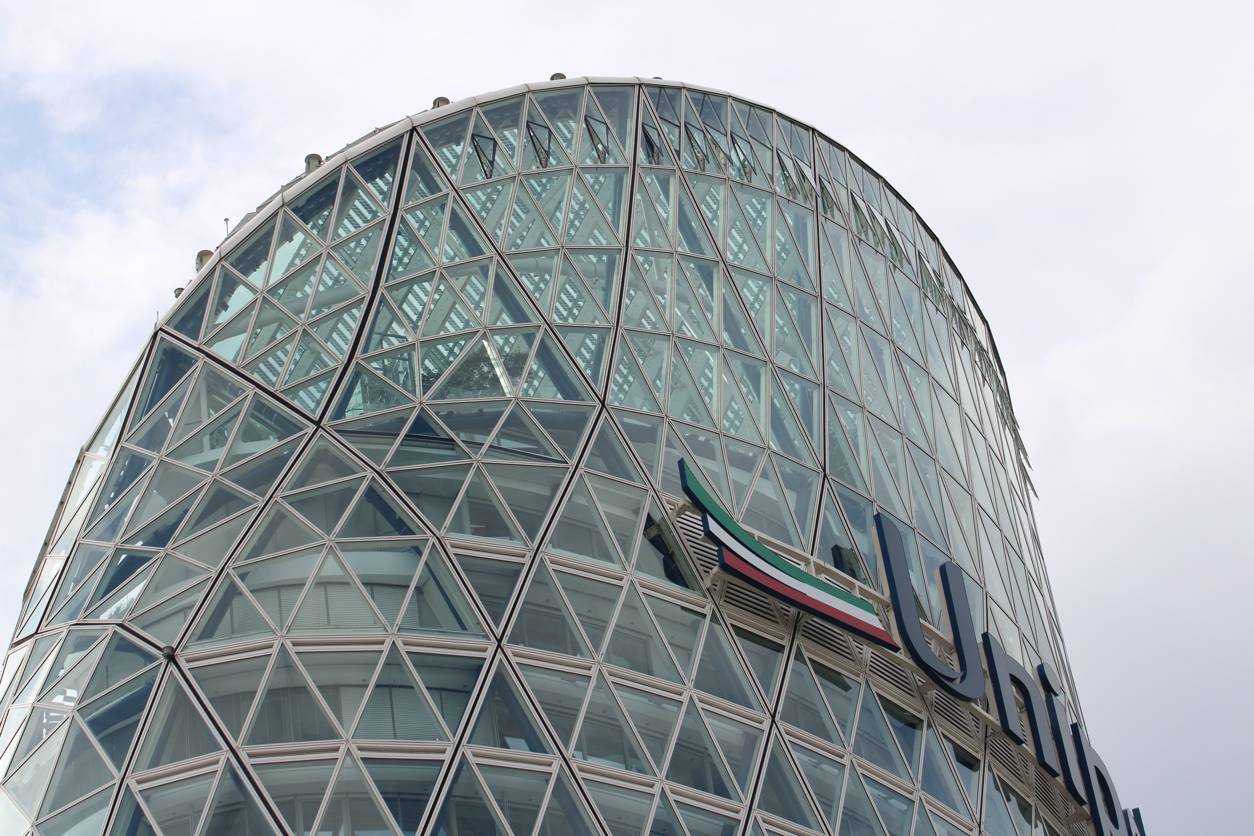 Close-up view of a modern glass skyscraper in Milan, Italy, showcasing architectural details.