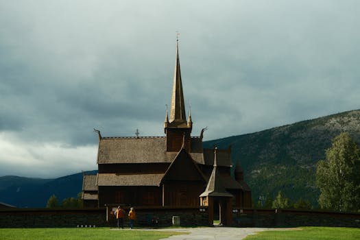 Majestic wooden stave church in Norway's scenic mountain landscape.