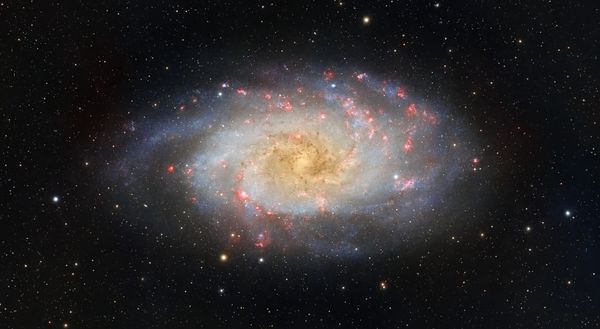 Imagem vibrante da Galáxia do Triângulo mostrando estrelas e nebulosas.