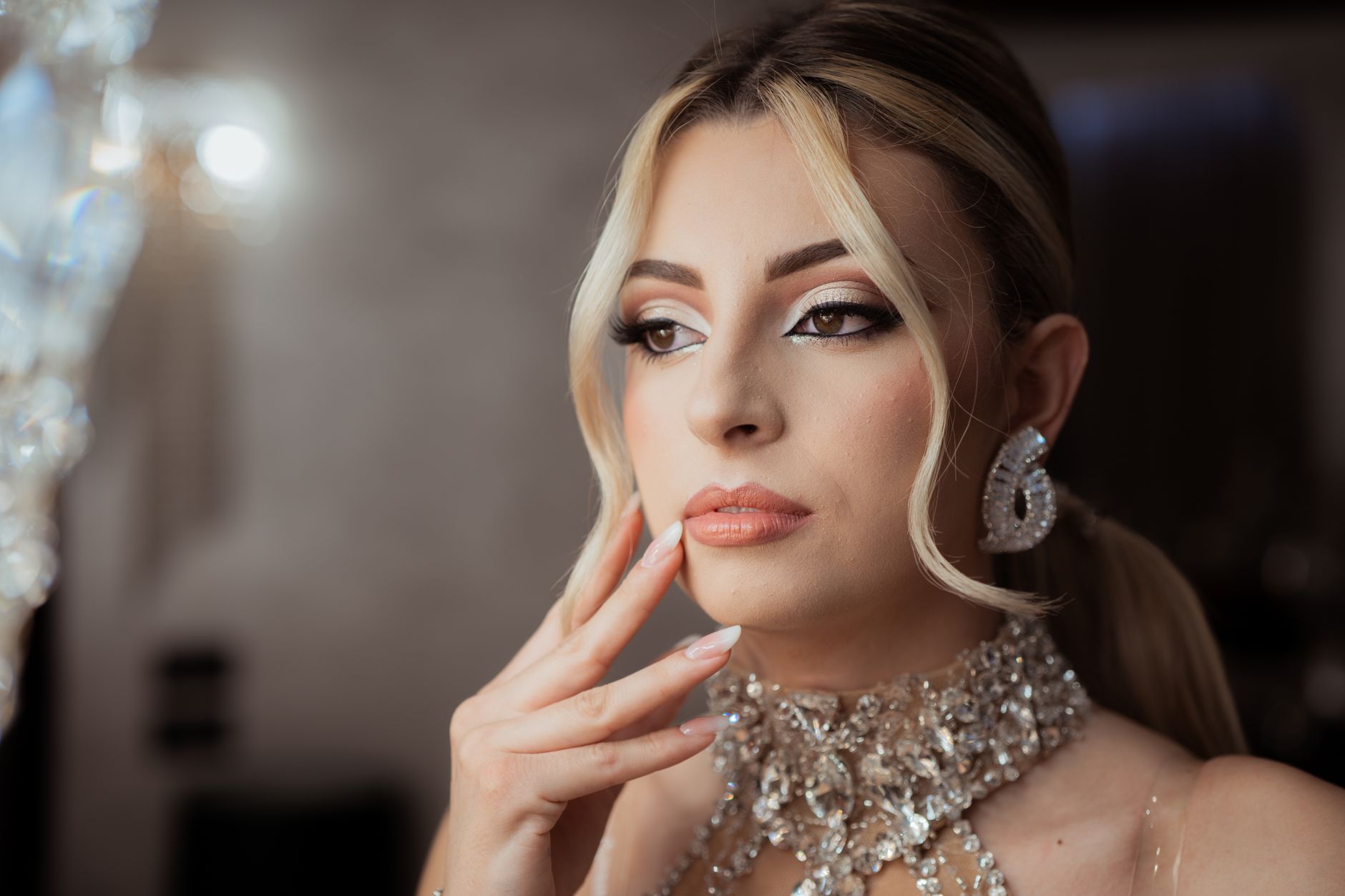 Sophisticated portrait of a woman in evening makeup and sparkling jewelry, exuding elegance and grace.
